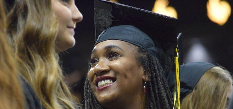 戴着黑色毕业帽的女子在毕业典礼上微笑